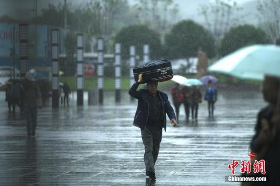 资料图:暴雨下民众出行。 陈超 摄 资料图:暴雨下民众出行。 陈超 摄
